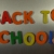 Hand Writes Back to School with Fridge Magnets Close-Up