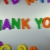 Hand Writes Thank You with Fridge Magnets Close-Up