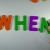 Hand Writes When with Fridge Magnets Close-Up