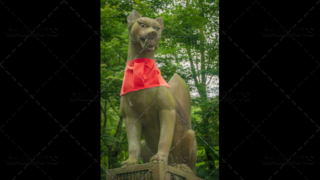 Fushimi Inari-taisha shrine, fox statue with red scarf. Kyoto, Japan.