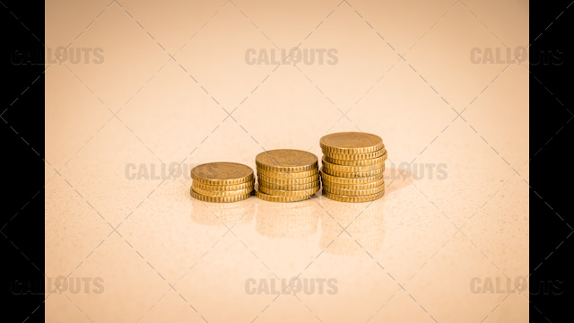 Three Stacks of Coins Increasing, on Shiny Table