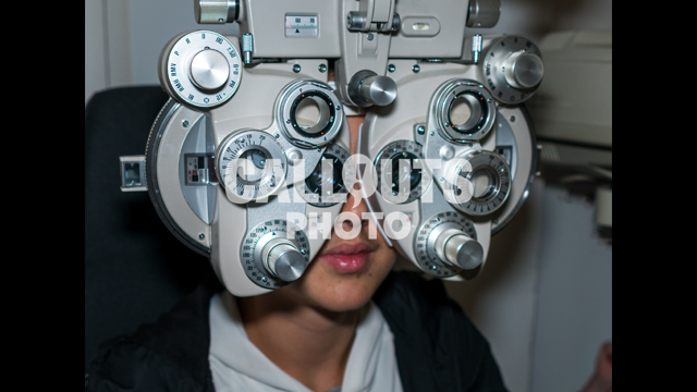 Young Teenage Boy Going Through Eye Exam, Ophthalmic Testing Device