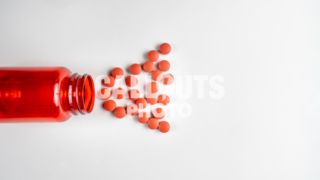 Red Medicine or Supplement Pills Pouring out of Red Bottle, White Background, Text Space