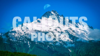 Snow covered mountain top with moon